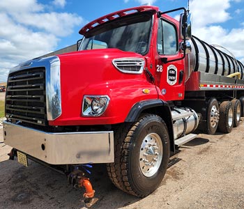 shiny clean water truck sits in the sun after being washed