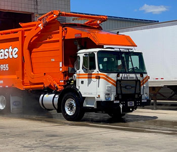 photo of a heavy duty municipal garbage truck in michigan leaving a hydrochem systems automated wash system looking clean and new