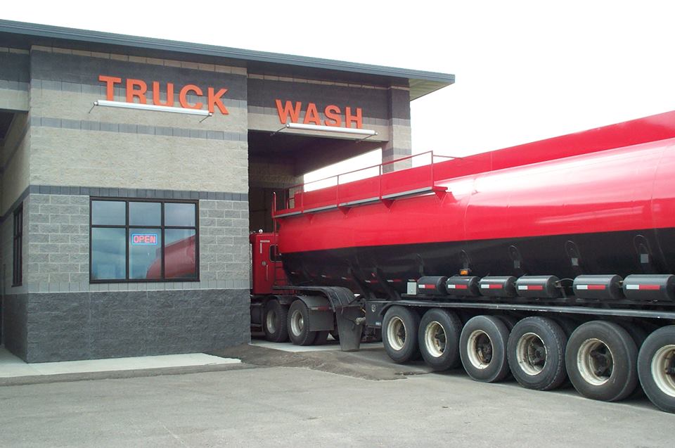 commercial truck with red tanker entering hydro-chem systems, inc. automated truck wash